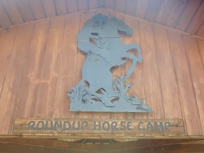 A metal sculpture depicting a cowboy on a bucking bronco at Roundup Horse Camp